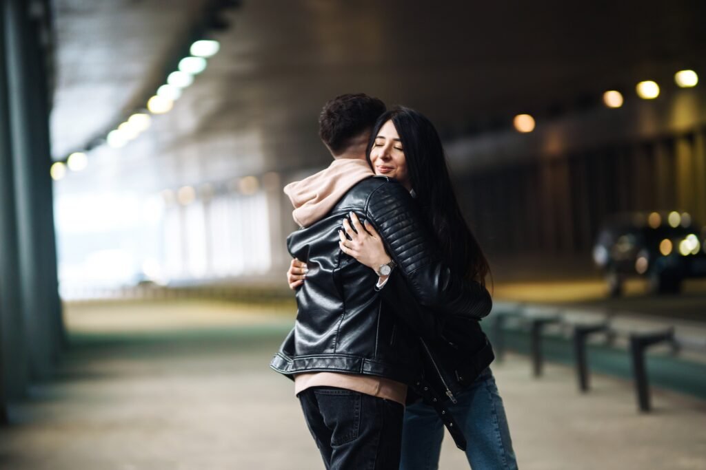 Young couple in love hug each other and kisses in underground crossing. Love story.
